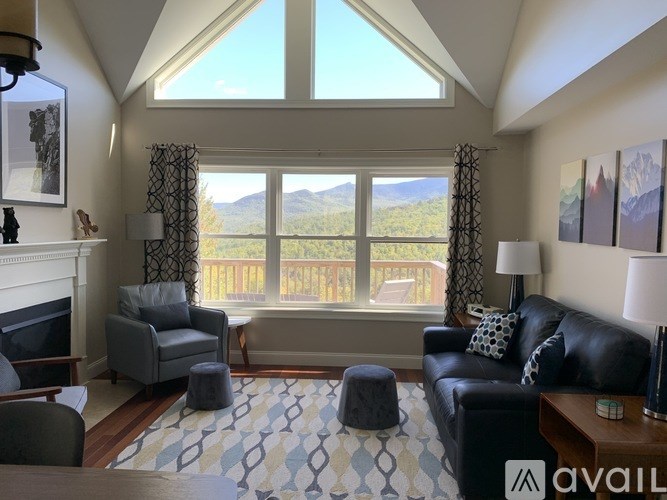 A living room with a fireplace and a view of the mountains.