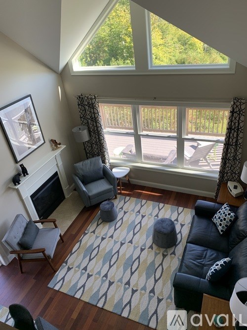 A living room with a fireplace and a large window.