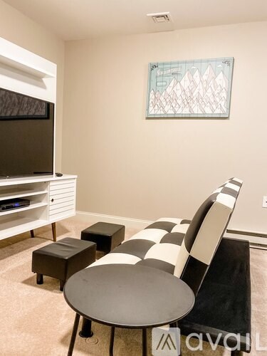 A living room with a black and white checkered chair and ottoman.