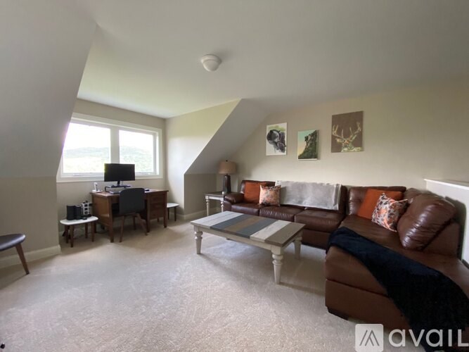 A living room with a brown couch and a coffee table.