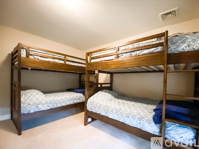 Two bunk beds in a room with white walls.