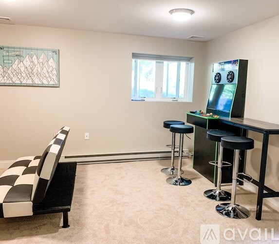 A room with a checkered chair and a bar area.