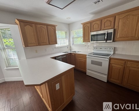 A kitchen with wooden cabinets and a white countertop.
