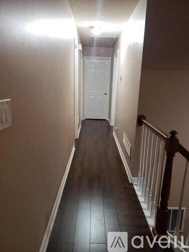 A hallway with a white door and a wooden banister.