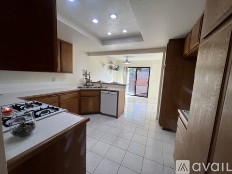 A kitchen with brown cabinets and a white stove top.