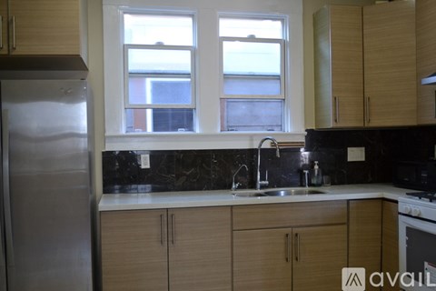 A kitchen with wooden cabinets and a stainless steel refrigerator.