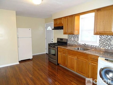A kitchen with wooden cabinets and a white refrigerator.