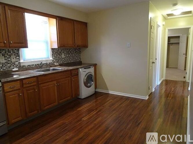 A kitchen with wooden cabinets and a white dishwasher.
