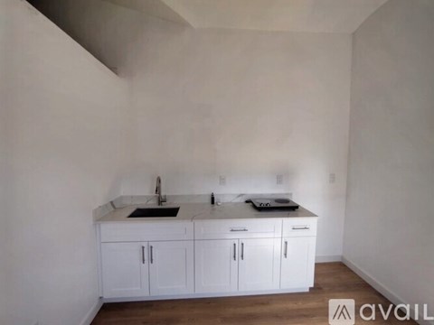 A kitchen with white cabinets and a sink.