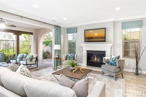 A living room with a fireplace and a television on the wall.