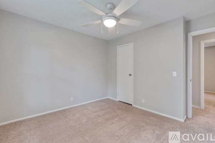 A room with a ceiling fan and carpeted floor.