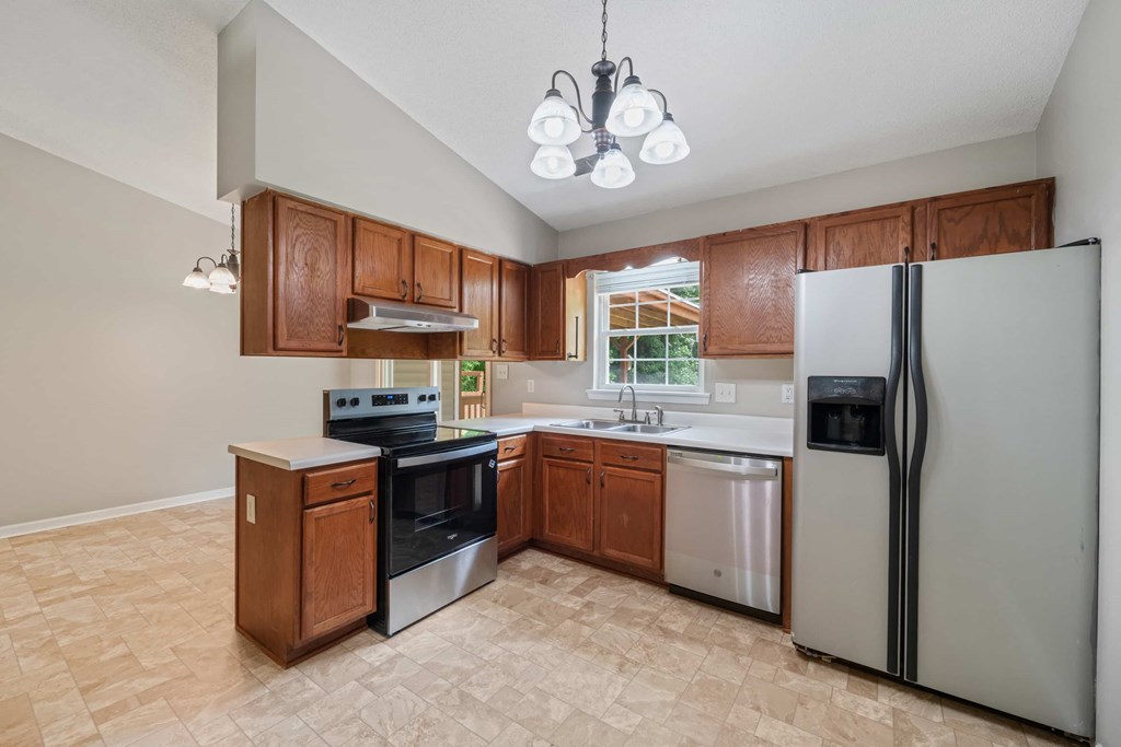A kitchen with a refrigerator, stove, and oven.