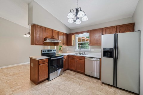 A kitchen with a refrigerator, stove, and oven.