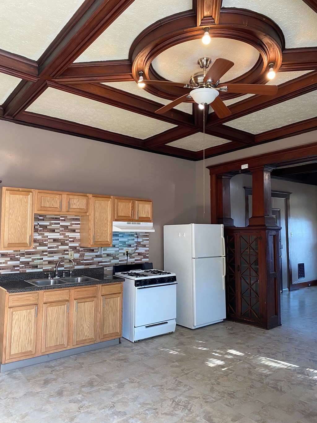 A kitchen with wooden cabinets and a white refrigerator.