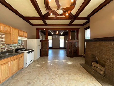 A kitchen with wooden cabinets and a brick fireplace.