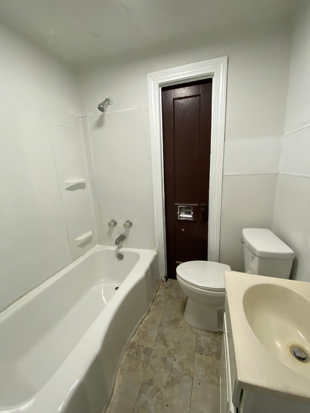 A white bathroom with a toilet, sink, and bathtub.