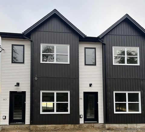 Three houses with black and white siding are shown.