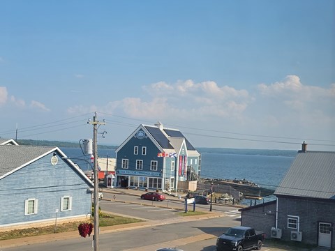 A small town with a blue building and a car parked in front.