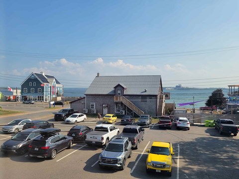 A parking lot with cars and a yellow taxi.