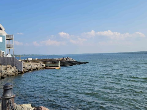 A view of a body of water with a dock and a building on the left side.