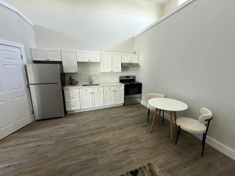 A kitchen with a table and chairs.