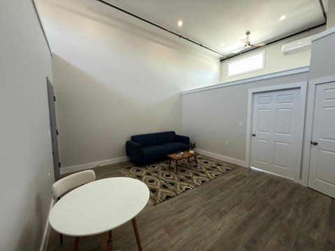 A room with a white table and a blue sofa.