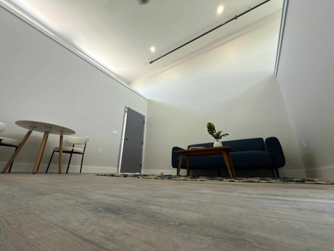 A room with a blue couch, a small table, and a chair.