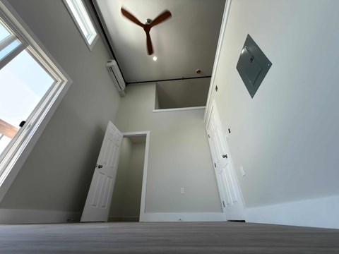 A room with a ceiling fan and a staircase.