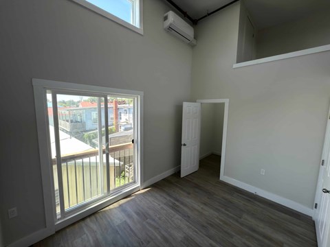 A room with a sliding glass door leading to a balcony.