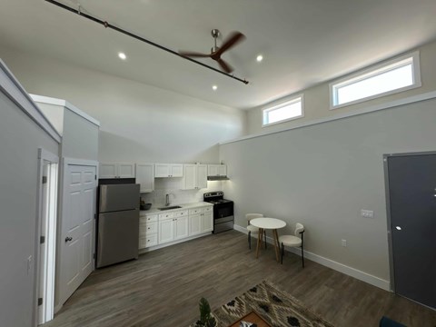 A kitchen with a refrigerator, stove, and sink.
