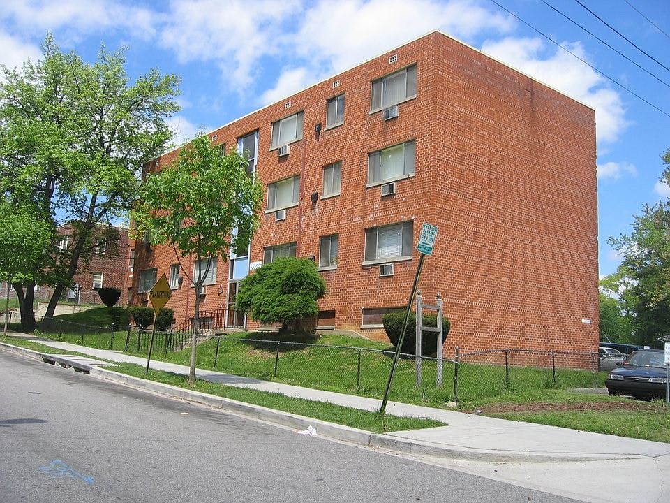 A red brick building with a green sign on the front.
