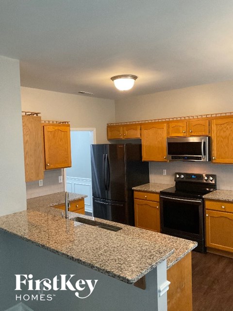 A kitchen with granite countertops and wooden cabinets.