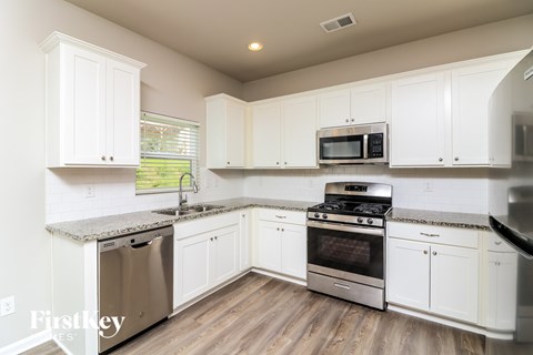 A kitchen with white cabinets and stainless steel appliances.