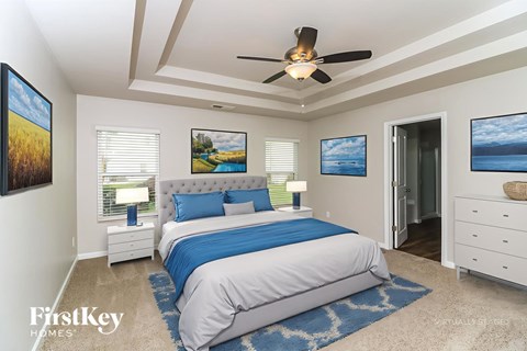 A bedroom with a bed, dresser, and ceiling fan.