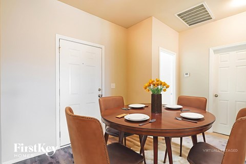A dining room with a round table set for six.