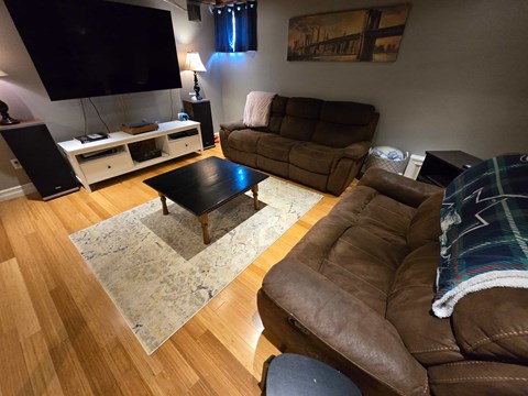A living room with a brown couch and a black coffee table.