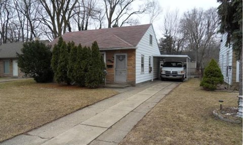 A house with a garage and a car parked in front.