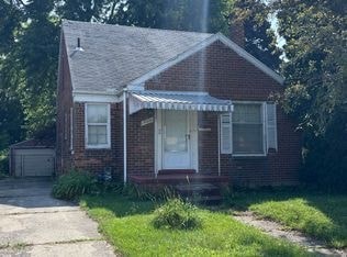 A small brick house with a white door and windows.