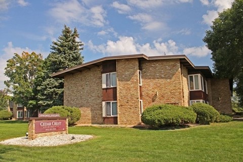 A brick building with a sign that says Cedar Crest in front of it.
