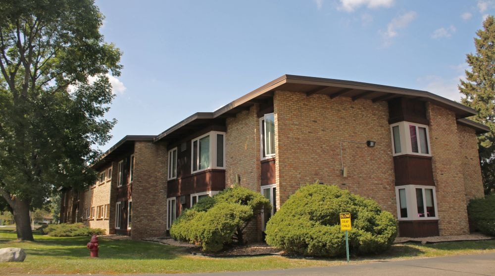 A brick building with a yellow sign in front.