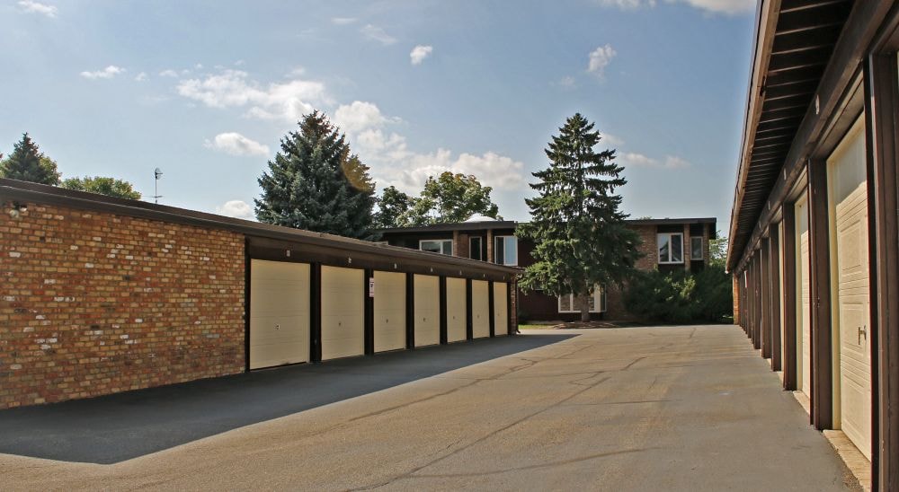 A long, narrow walkway with a brick wall on one side and a row of buildings on the other.