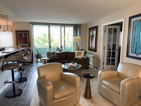 A living room with a white couch and a brown chair.