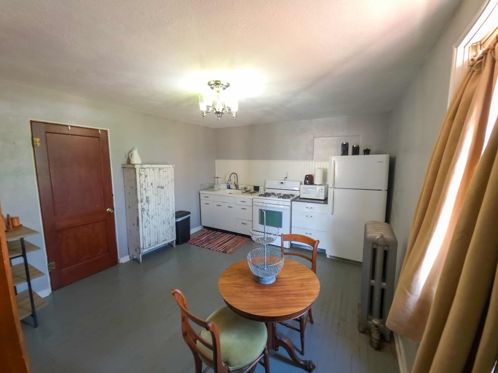 A kitchen with a table and chairs in the middle of the room.