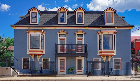 A two-story house with a balcony and a black fence.