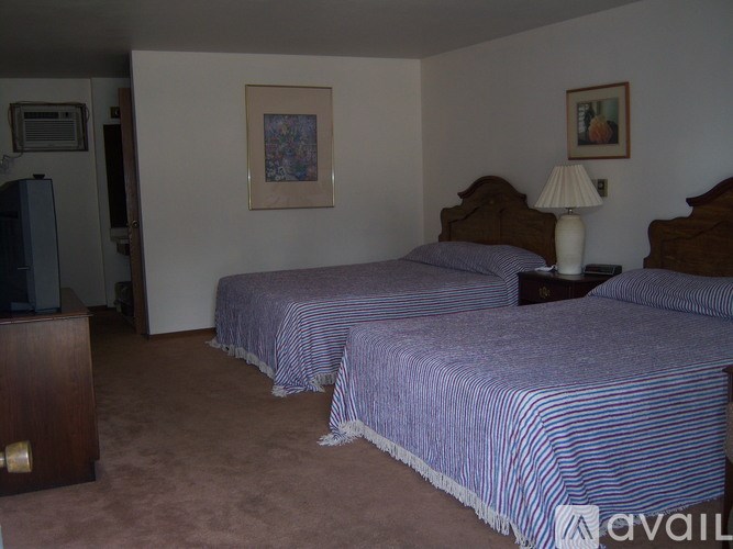 Two twin beds with blue striped bedspreads in a room.