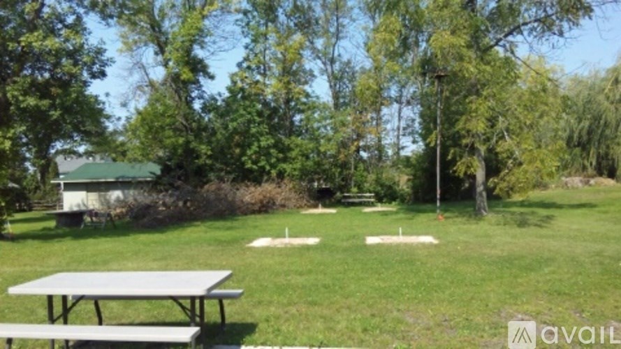 A picnic table is in the middle of a grassy field.