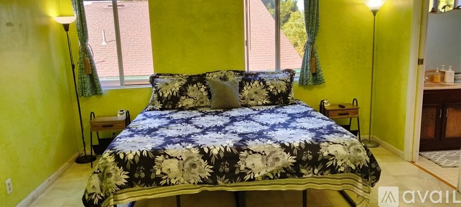 A bed with a blue and white comforter is in a room with yellow walls.