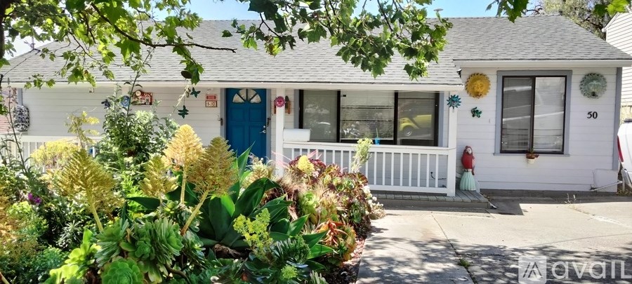 A white house with a blue door and a white porch.