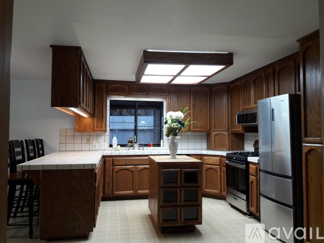 A kitchen with wooden cabinets and a large island.