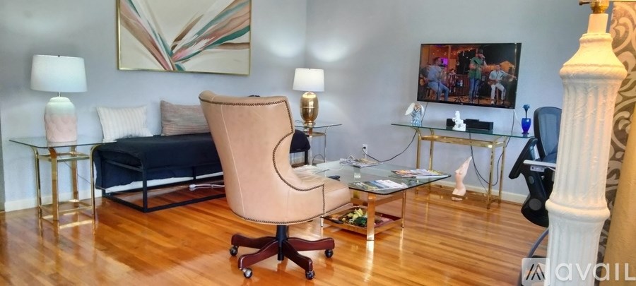 A living room with a couch, chair, and painting on the wall.